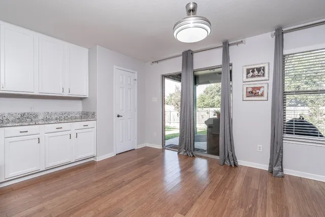 a kitchen with granite countertop a stove a sink and dishwasher wooden cabinets with wooden floor