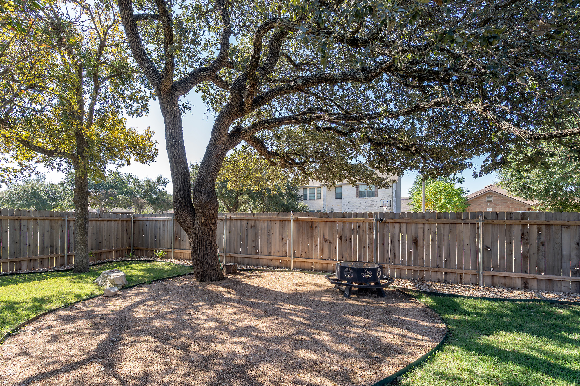 328 Cedar Lake Boulevard Georgetown, TX 78633 - Photo 30 of 34 a view of a small yard in front of a house with wooden fence and large trees