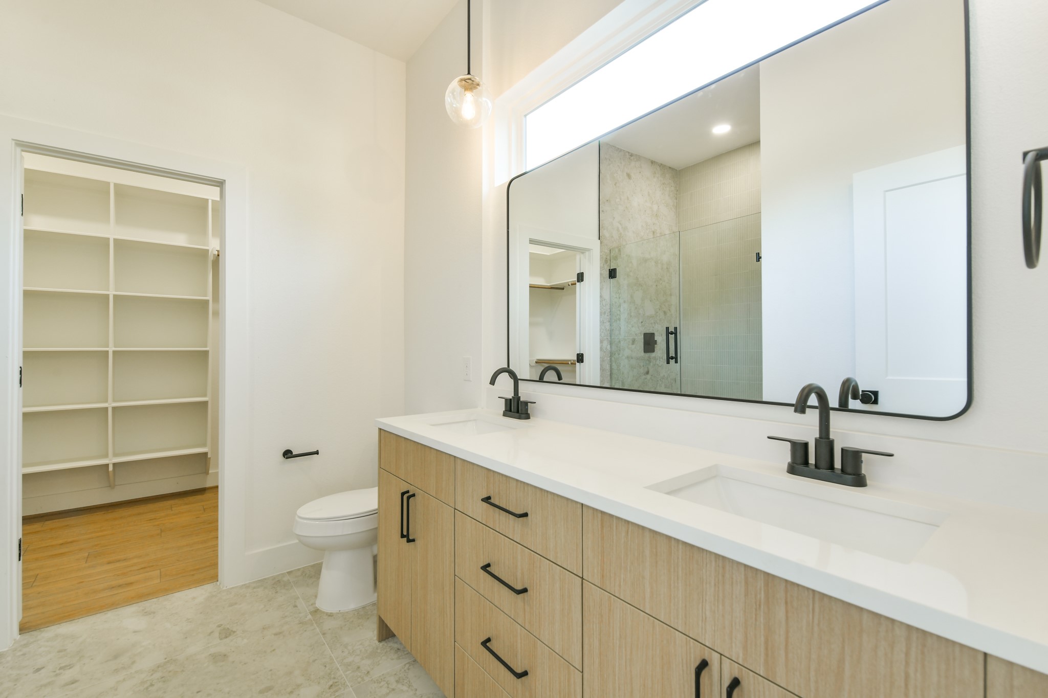 164 Wallace Street Houston, TX 77022 - Photo 11 of 29 a bathroom with a double vanity sink a toilet and a mirror