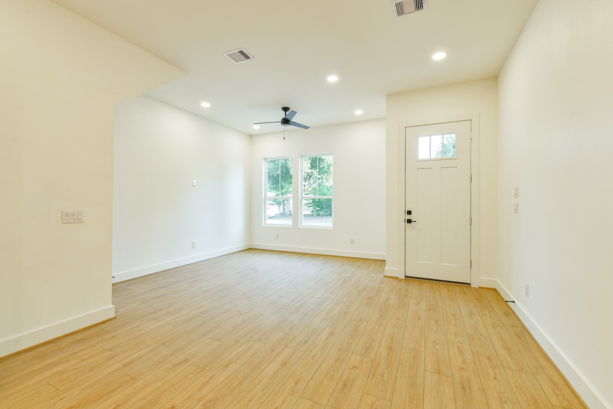 164 Wallace Street Houston, TX 77022 - Photo 6 of 29 an empty room with wooden floor and windows