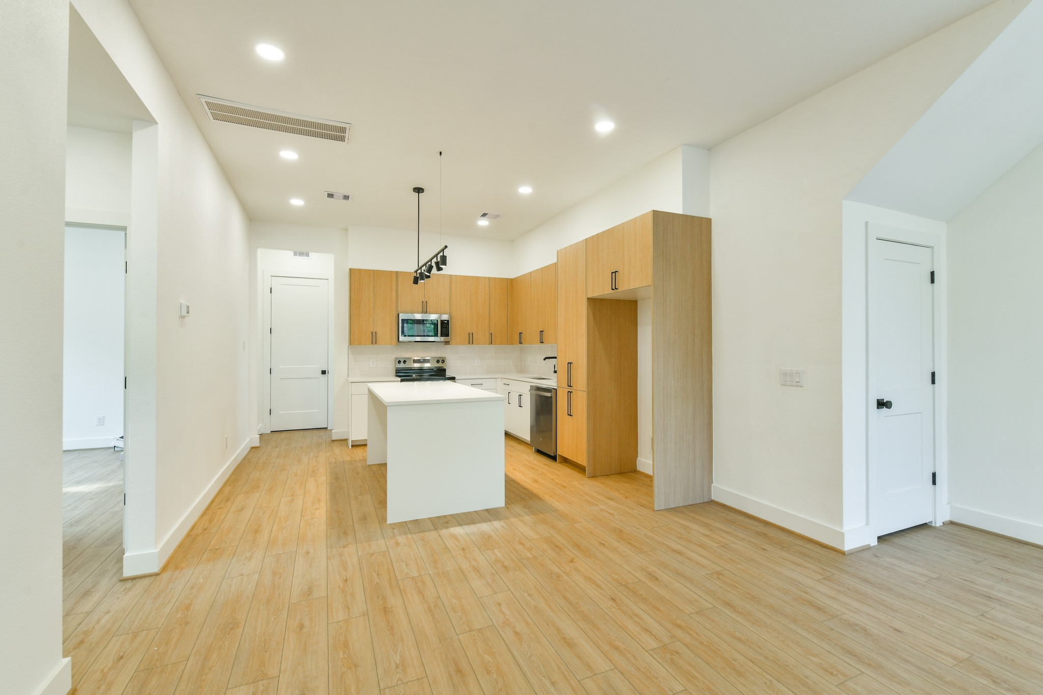 164 Wallace Street Houston, TX 77022 - Photo 8 of 29 a view of kitchen with stainless steel appliances refrigerator oven and white cabinets with wooden floor