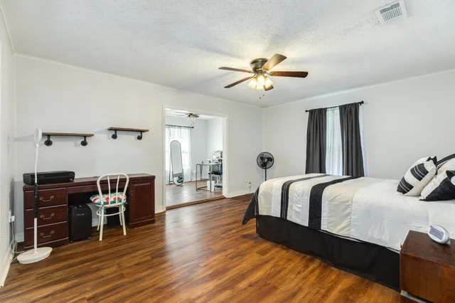 a bedroom with a bed and wooden floor