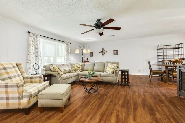 a living room with furniture and a wooden floor