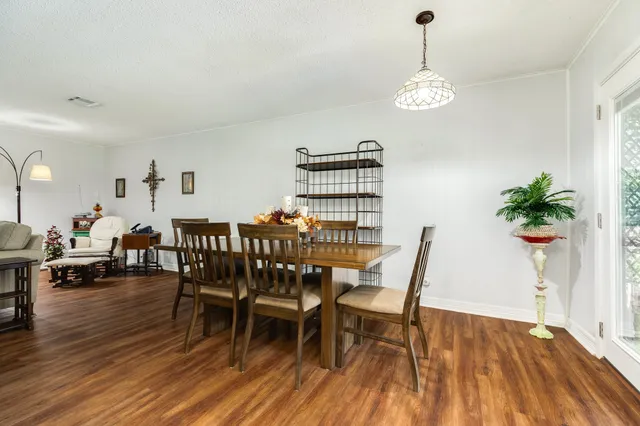 a dining room with furniture potted plants and wooden floor
