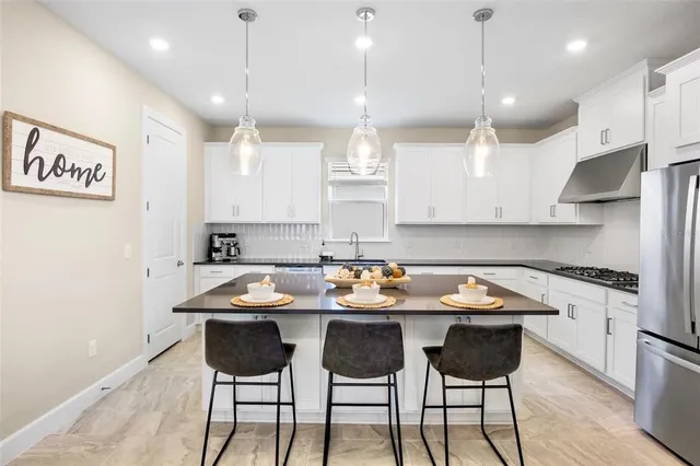 a kitchen with a table chairs stove and cabinets