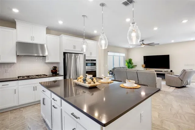 a kitchen with stainless steel appliances granite countertop a sink a stove and a refrigerator