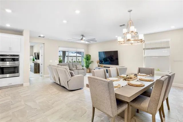 a view of a dining room with furniture a livingroom and chandelier