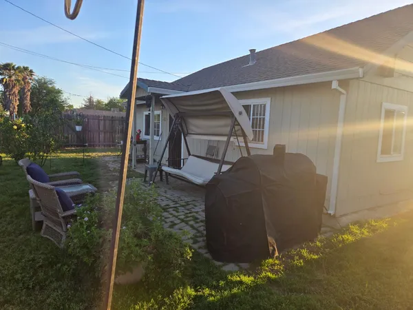 a backyard of a house with table and chairs