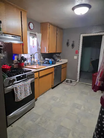 a kitchen with stainless steel appliances granite countertop a stove a sink and a refrigerator