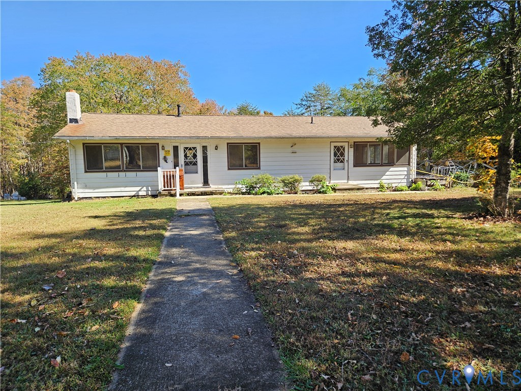 a front view of house with yard slide and large trees