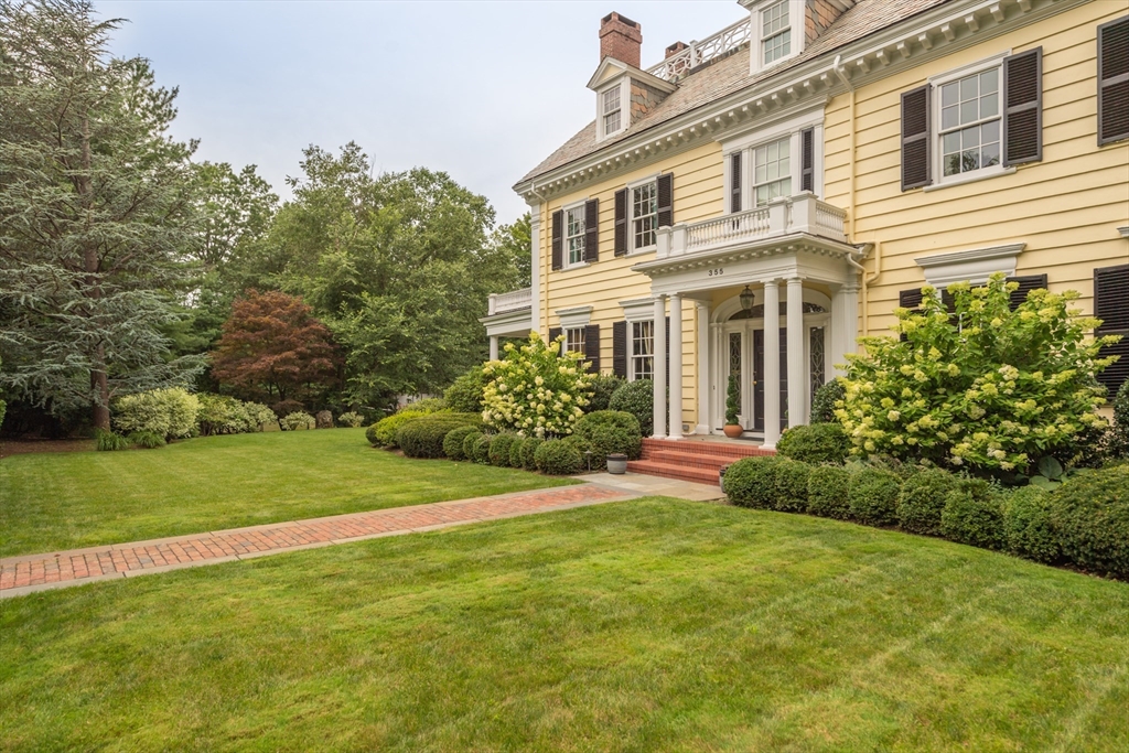 a front view of a house with a yard and trees