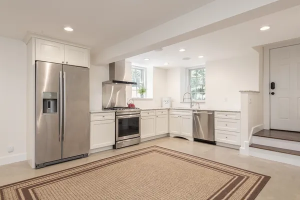 a kitchen with white cabinets and stainless steel appliances
