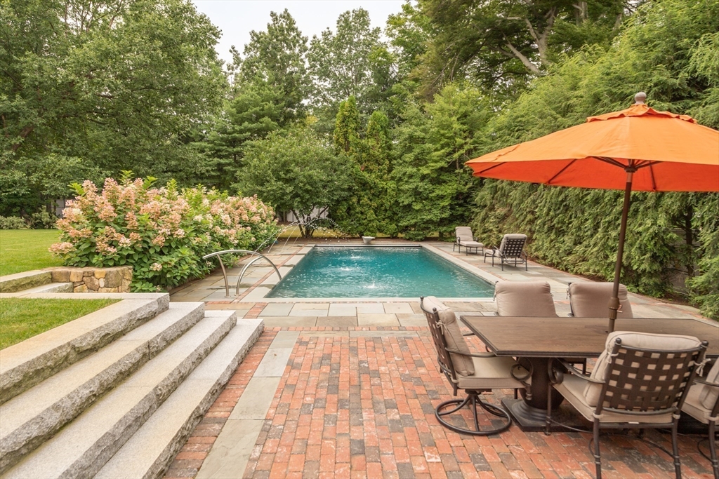 355 Buckminster Road Brookline, MA 02445 - Photo 25 of 32 a view of a patio with chairs and table under an umbrella