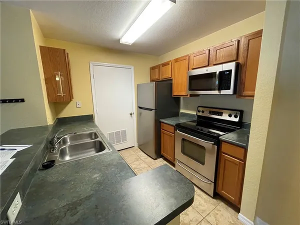a kitchen with stainless steel appliances a stove a microwave a sink and a microwave