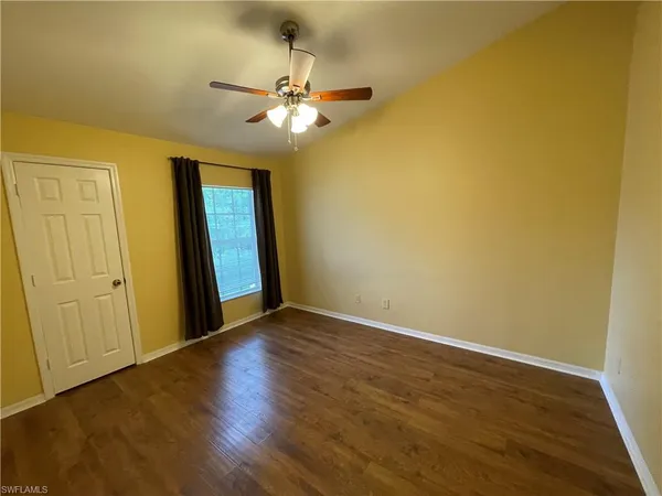 a view of empty room with wooden floor