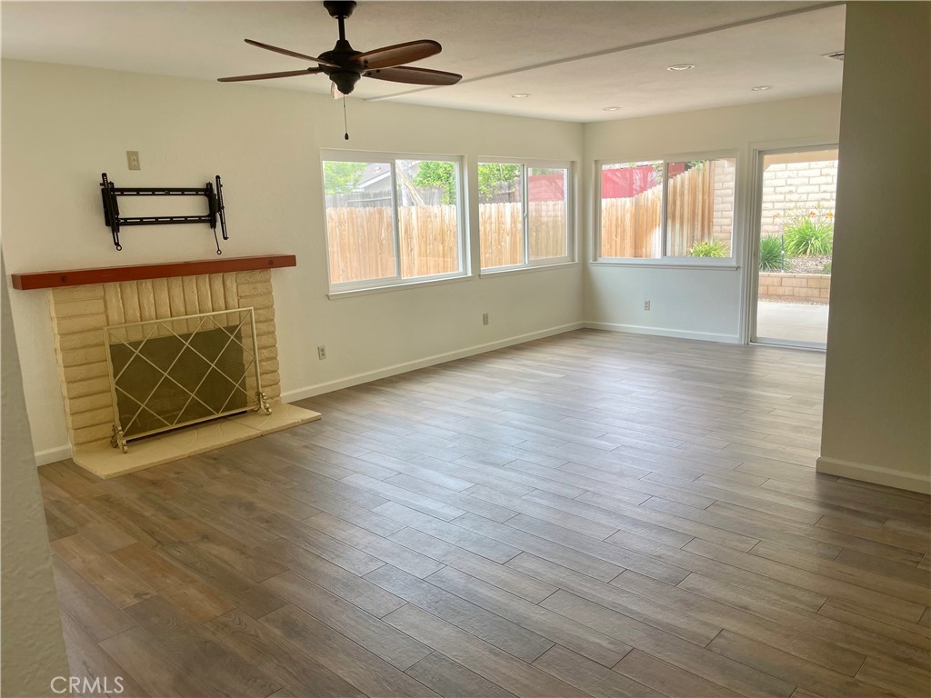 4317 Ardsley Court Riverside, CA 92505 - Photo 2 of 7 an empty room with wooden floor fan and windows