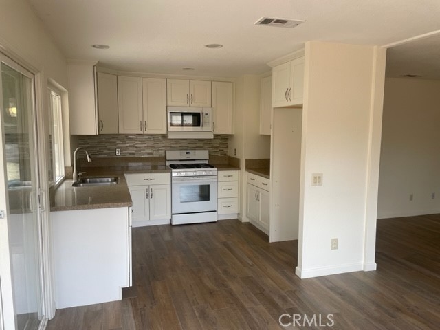 4317 Ardsley Court Riverside, CA 92505 - Photo 3 of 7 a kitchen with stainless steel appliances granite countertop a refrigerator a stove top oven a sink and dishwasher with wooden floor