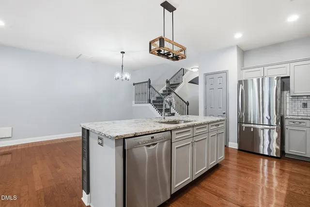 a kitchen with a counter space a sink and stainless steel appliances