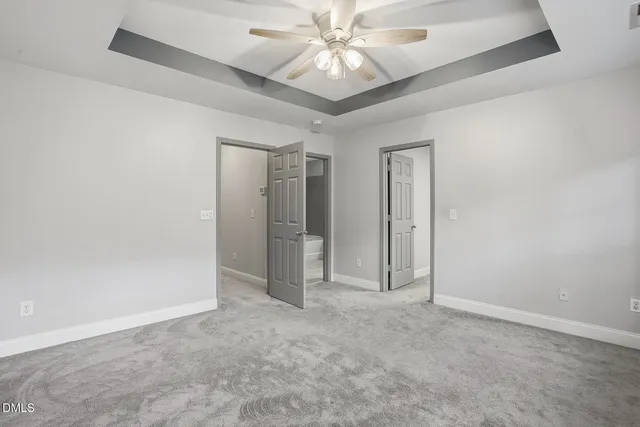 an empty room with closet and a ceiling fan