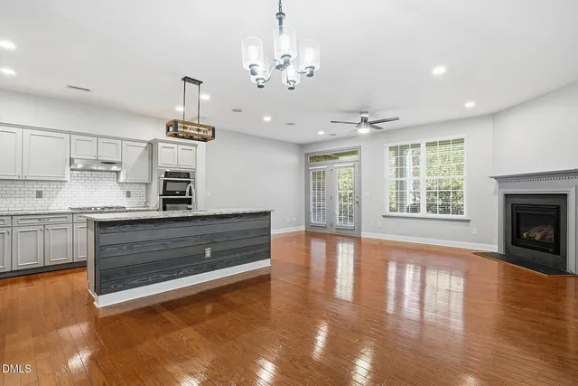 a kitchen with stainless steel appliances granite countertop a stove and a wooden floors