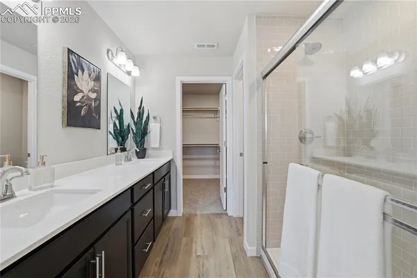 a bathroom with a granite countertop sink a large mirror and a shower