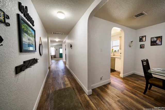 a hallway with wooden floor furniture and a bathroom