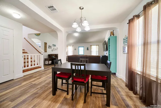 a view of a dining room with furniture and a chandelier