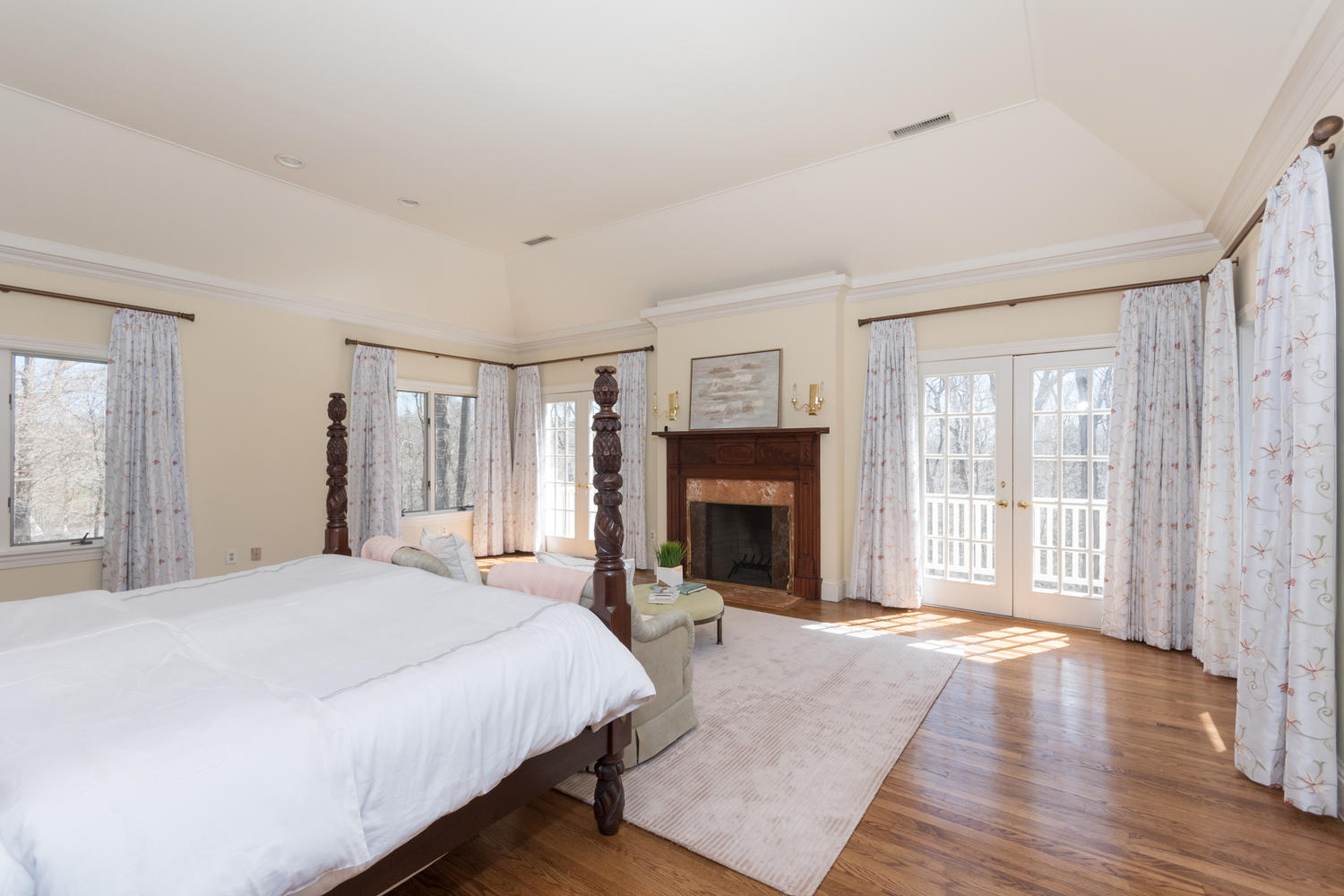 123 Lone Tree Farm Road New Canaan, CT 06840 - Photo 17 of 22 a spacious bedroom with a balcony a bed and a fireplace
