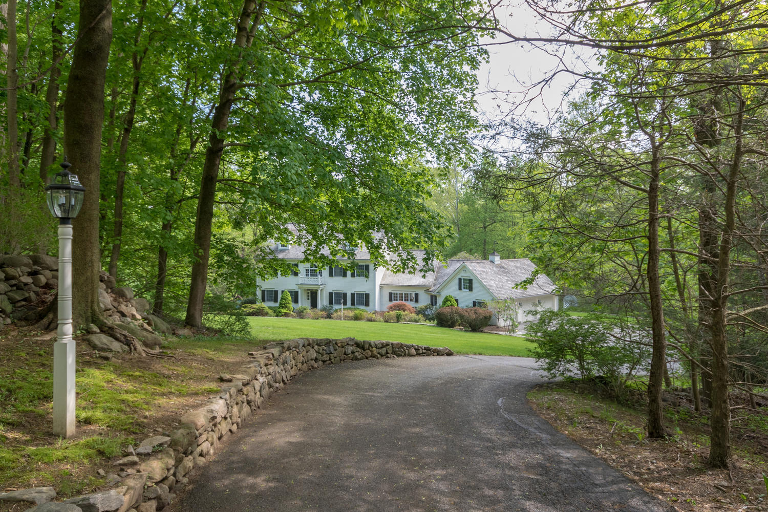 123 Lone Tree Farm Road New Canaan, CT 06840 - Photo 22 of 22 a front view of a house with a yard and trees