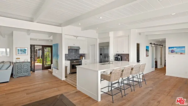 a large white kitchen with sink and refrigerator