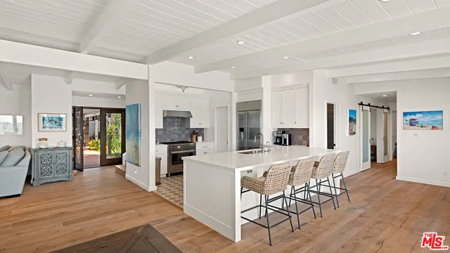 a large white kitchen with sink and refrigerator