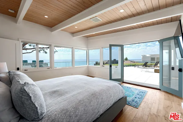 a large bedroom with a large bed and wooden floor