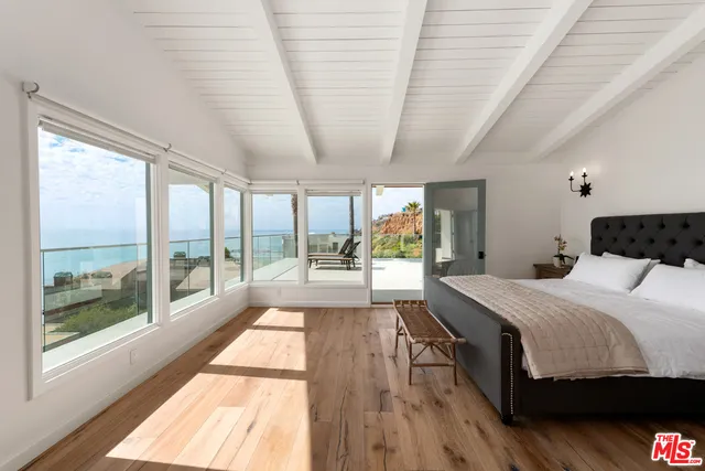 a bedroom with a large bed and a large window