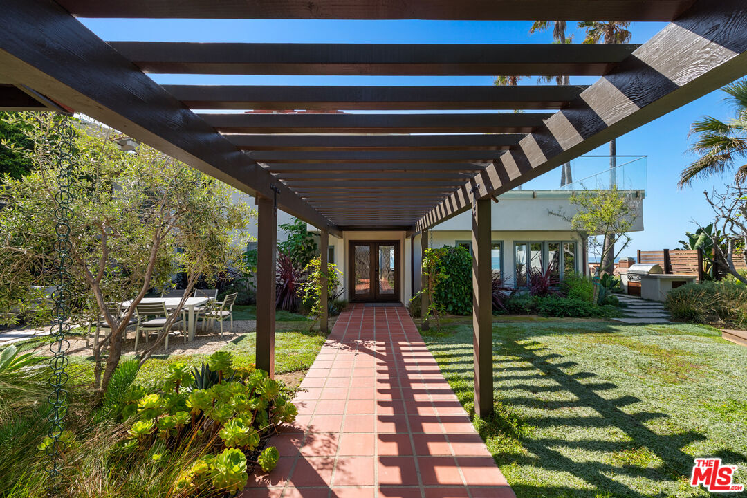 32054 Pacific Coast Highway Malibu, CA 90265 - Photo 3 of 48 a view of a patio with table and chairs potted plants and large tree