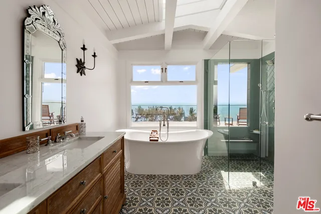 a bathroom with a double vanity sink a mirror and a bathtub