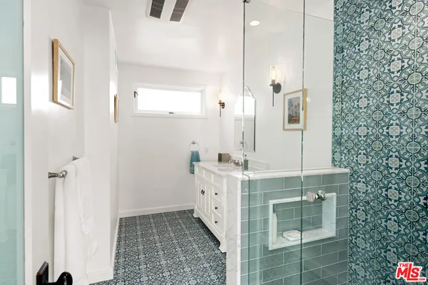a spacious bathroom with a double vanity sink a mirror and a shower