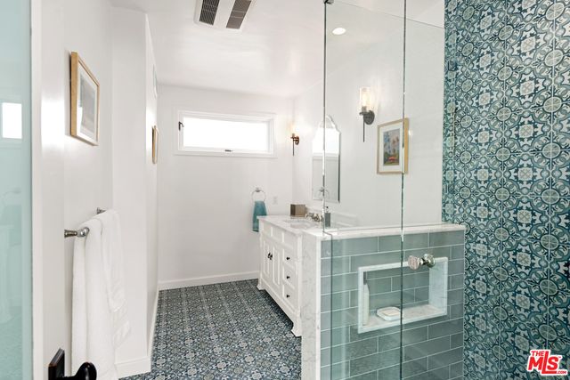 a spacious bathroom with a double vanity sink a mirror and a shower