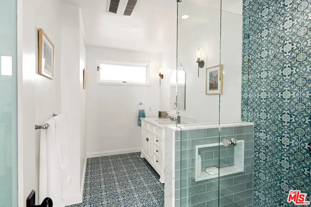 a spacious bathroom with a double vanity sink a mirror and a shower