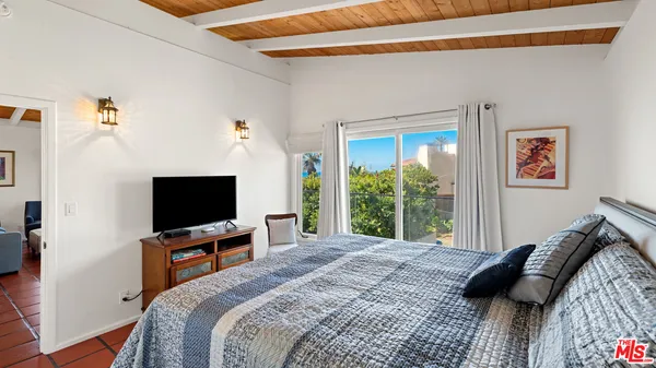 a bedroom with a bed and a flat screen tv