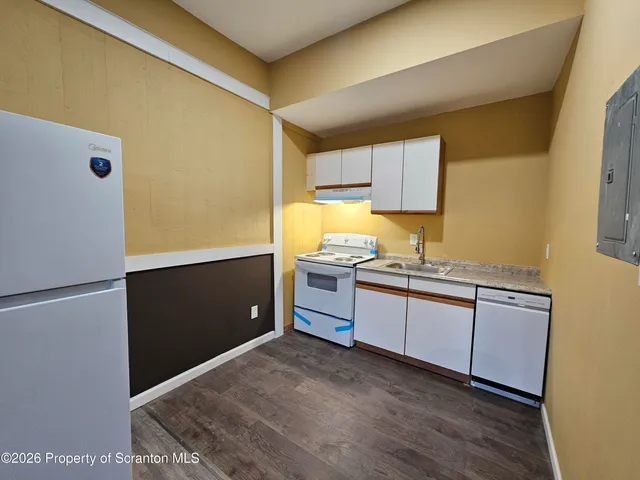 a kitchen with granite countertop a refrigerator and a sink