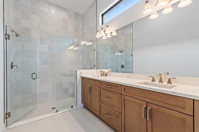 a bathroom with a double vanity sink mirror and shower