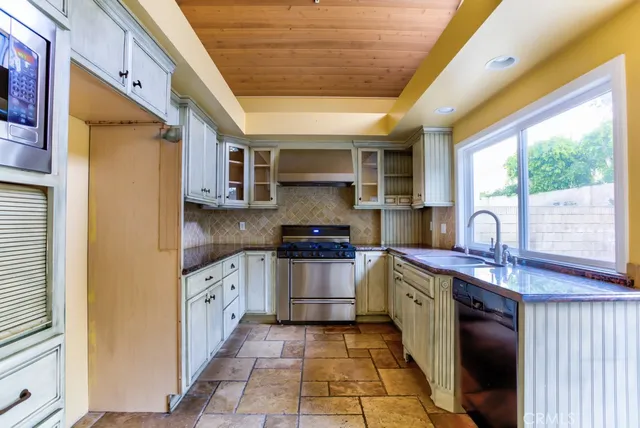 a kitchen with stainless steel appliances granite countertop a stove sink and cabinets