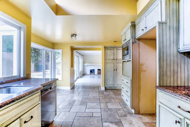 a bathroom with a granite countertop sink a mirror a bathtub and next to a window