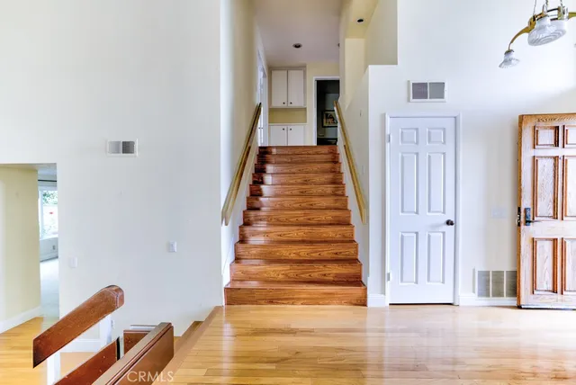 a view of a hallway with wooden floor and entryway