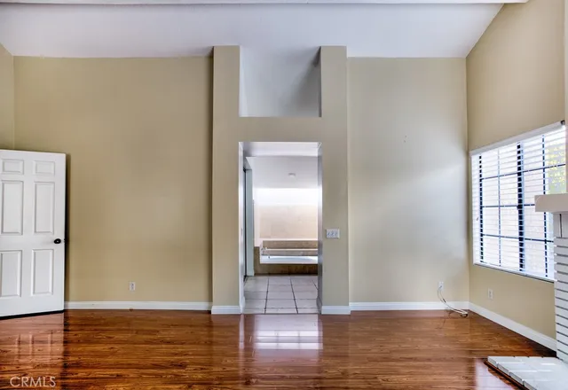 a view of a hallway with wooden floor and kitchen