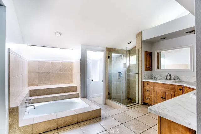 a bathroom with a tub a sink and a large mirror