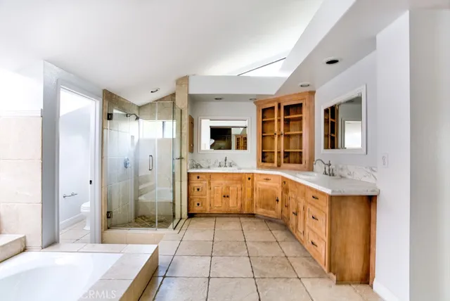 a bathroom with a granite countertop sink mirror and cabinets
