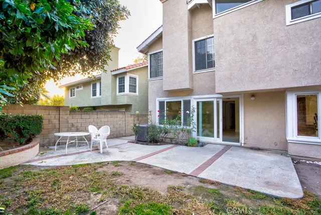 a view of a chair and table in backyard of the house