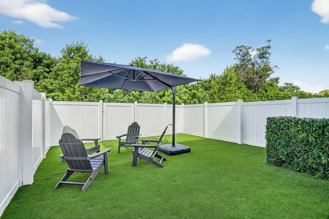 a front view of a house with garden and sitting area