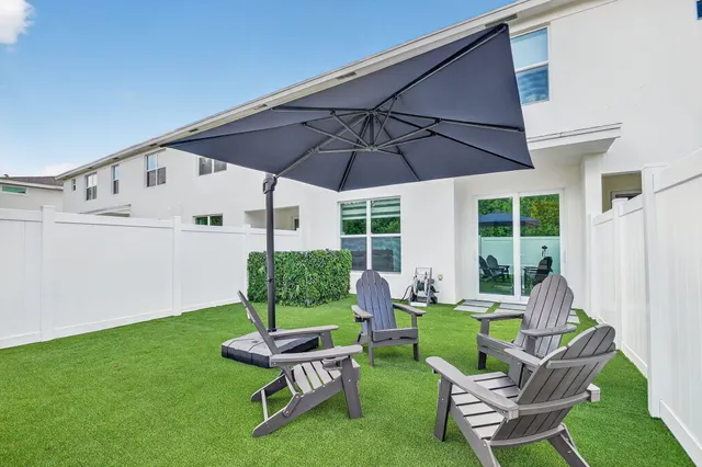 a view of a chair and table in backyard of the house
